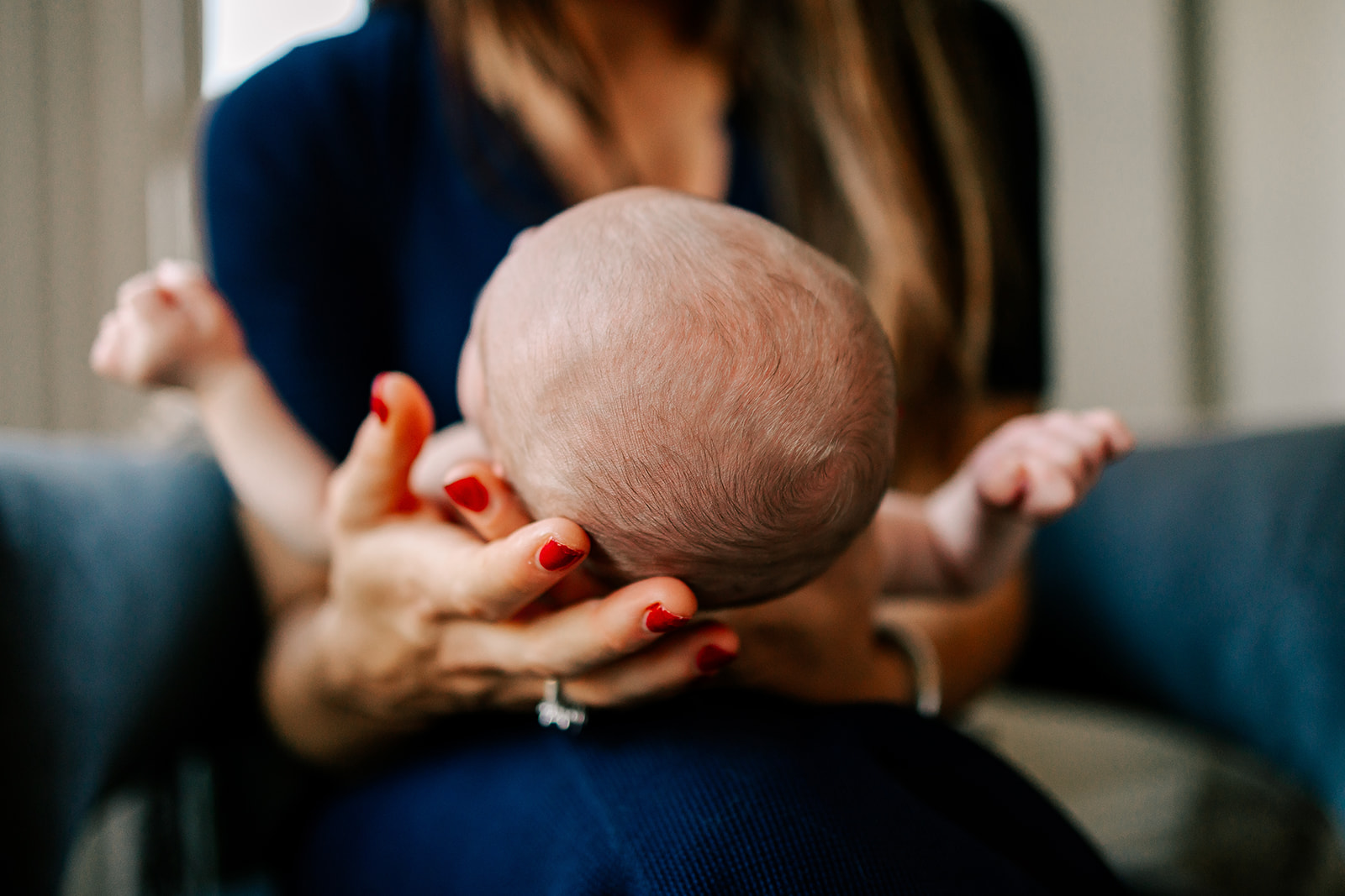 Details of the top of a newborn baby's head in mom's hands