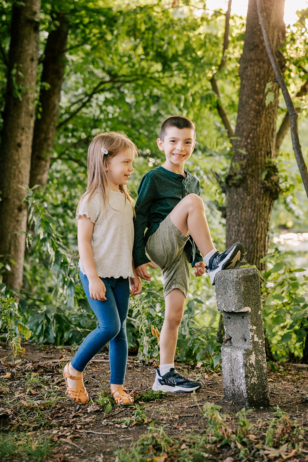 A toddler boy and younger sister explore a park trail