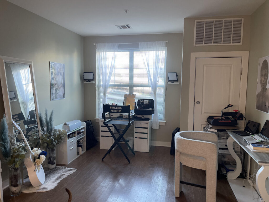Makeup artist's home studio, with vanity, lights, and several chairs.
